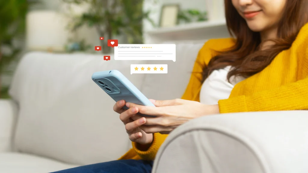 Woman sitting on sofa in Los Angeles leaving an online review on her phone