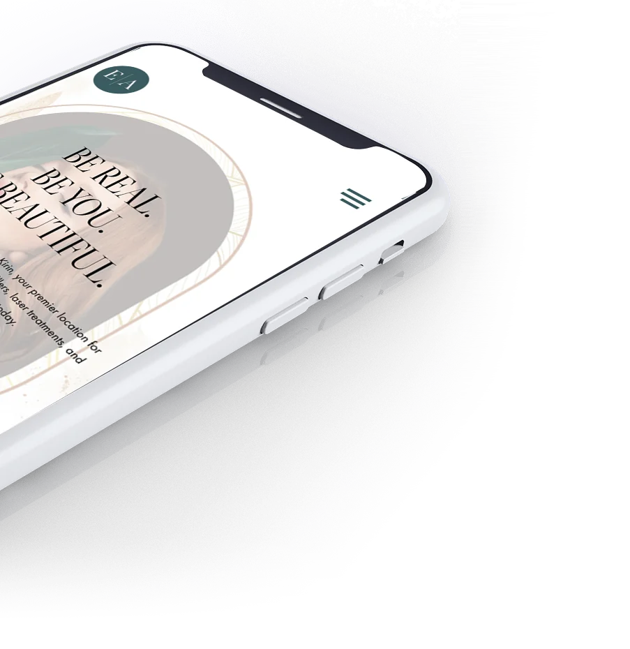 The Emerald Aesthetics homepage on a phone, tilted.