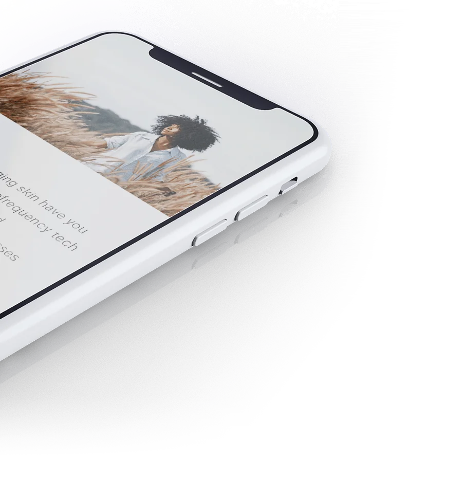 The iAesthetic homepage on a phone, tilted.