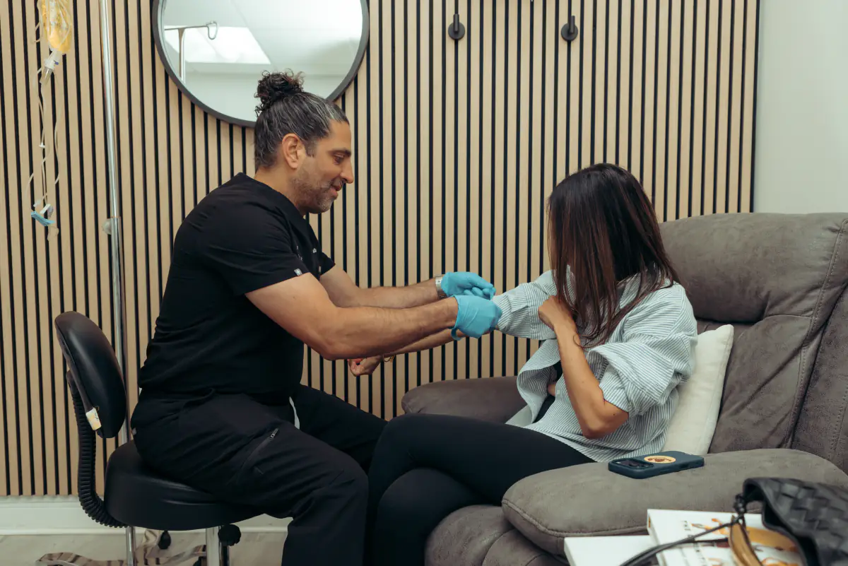 A physician starting an IV for a patient in a recliner.