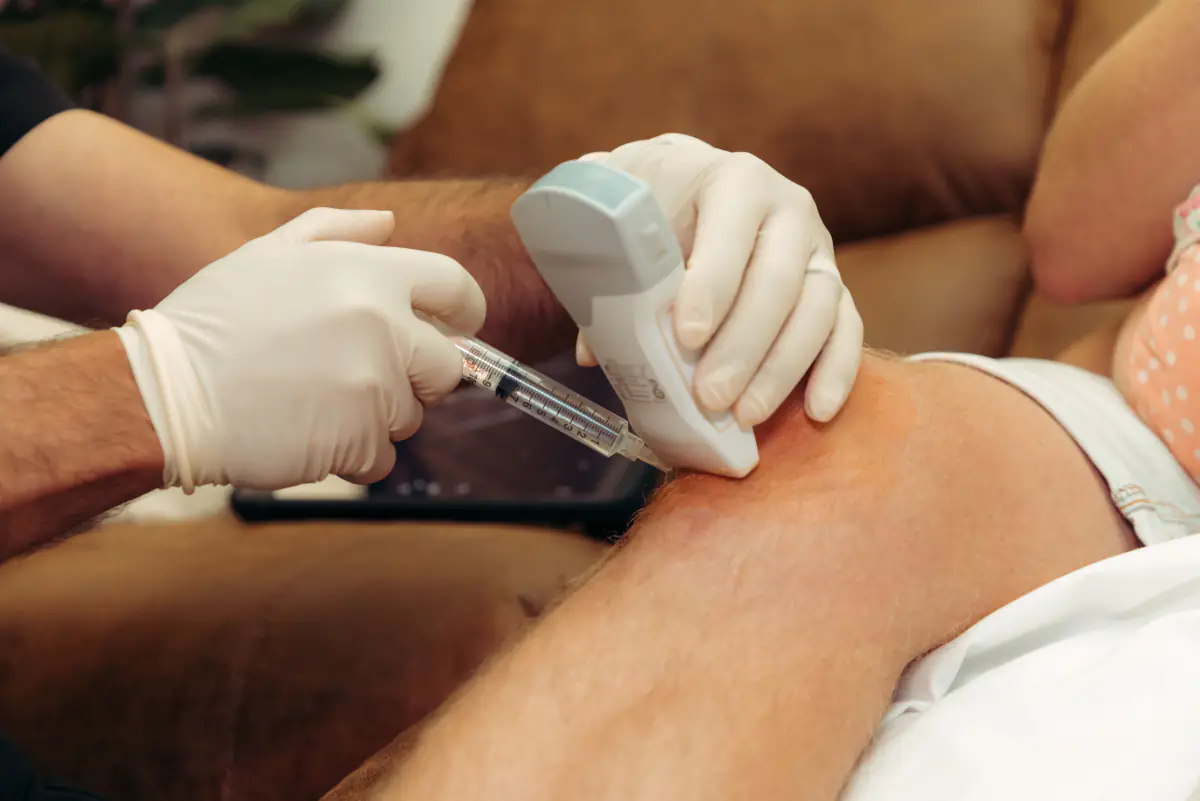 A physician guiding an injection into a knee by ultrasound.