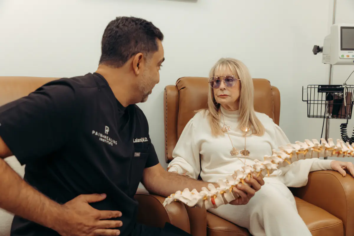 A physician walking a patient through a spine model, an unposed moment from the shoot.