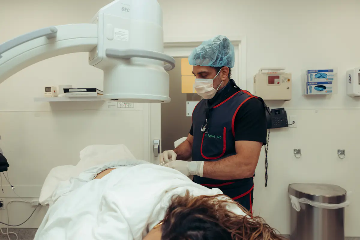 A physician preparing a patient under the C-arm.
